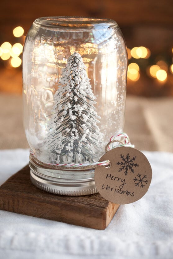 A snowy tree and glitter inside a mason jar
