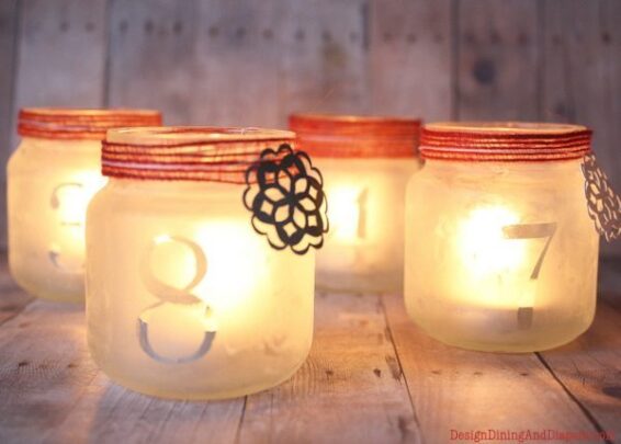 Frosted jars with numbers on them and lighted tea candles on the inside