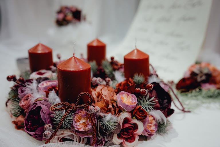 Warm, festive candle wreath adorned with floral decorations, perfect for Christmas table settings.